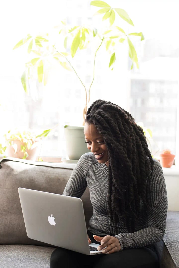 Smiling woman reviewing business reports on a laptop